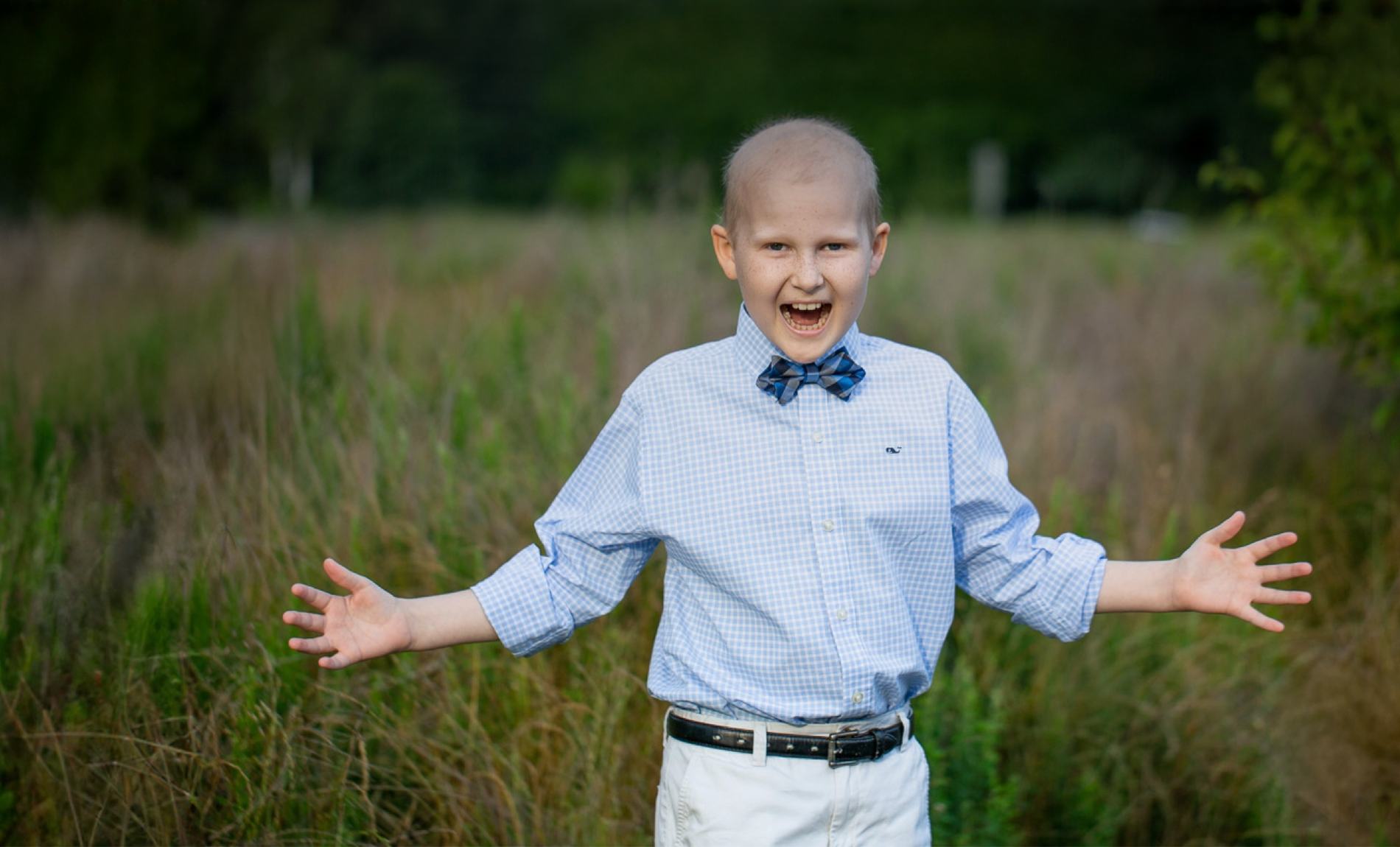 Rally Kid Lex standing in a field with his arms open wide