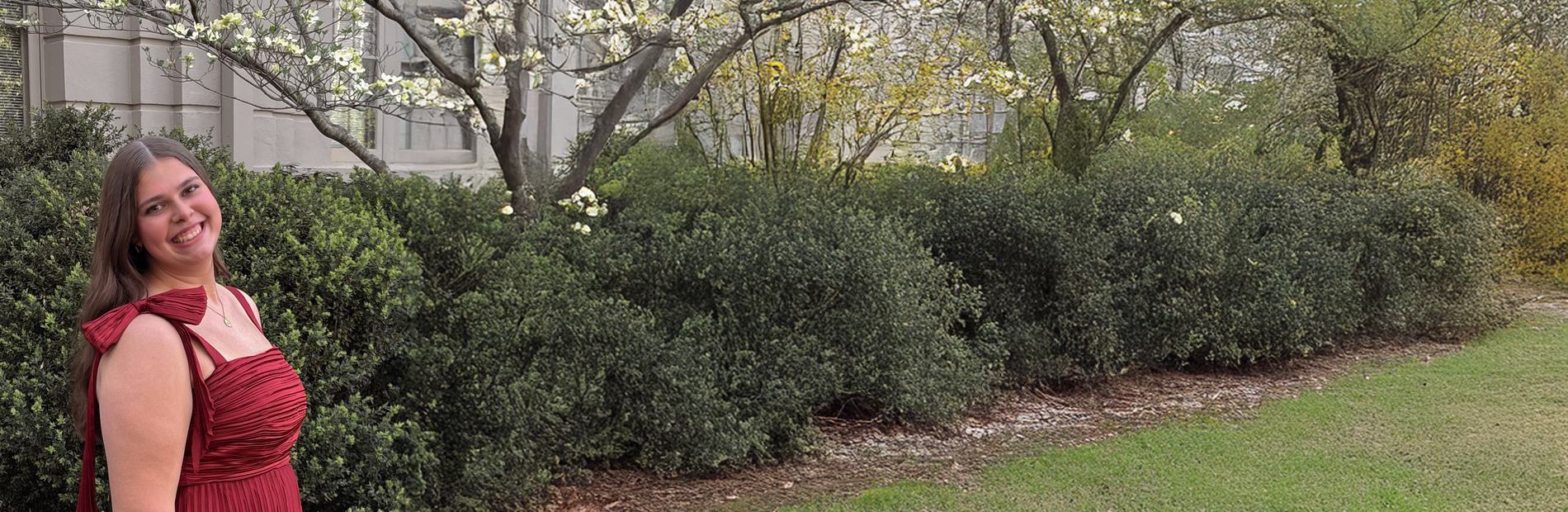 Rally Kid Katey standing outdoors by flowering shrubs