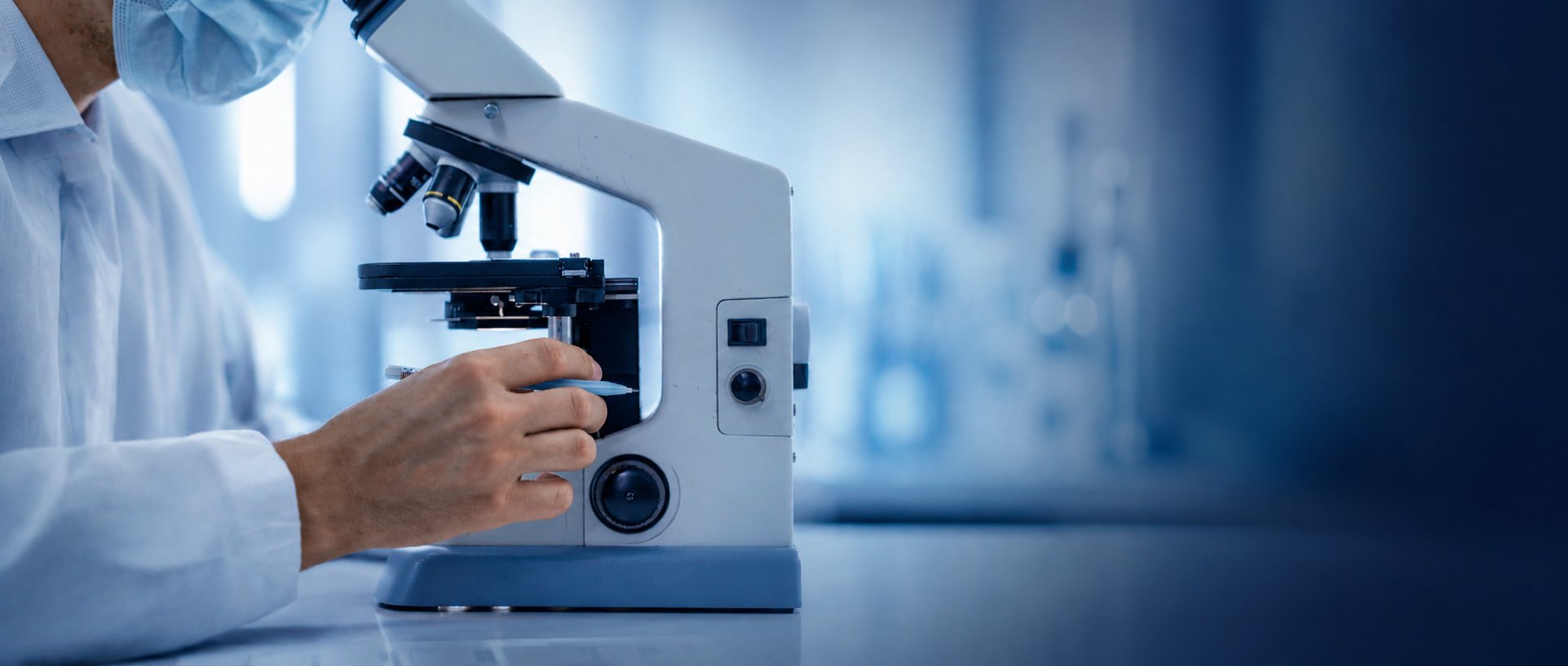 A researcher at a microscope in a laboratory
